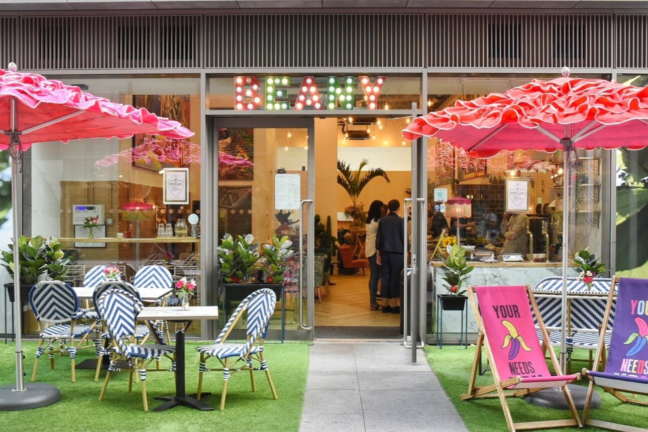 Vibrant outdoor café with colorful umbrellas, ideal for casual meetings and networking events.