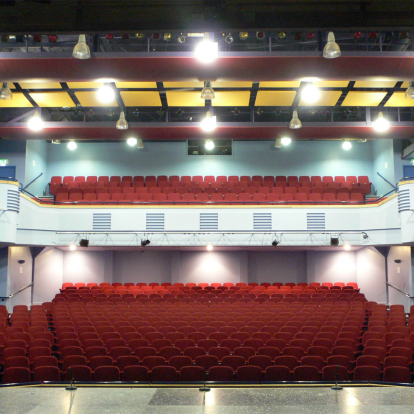 Lighthouse Theatre auditorium with red tiered seating for events and presentations.