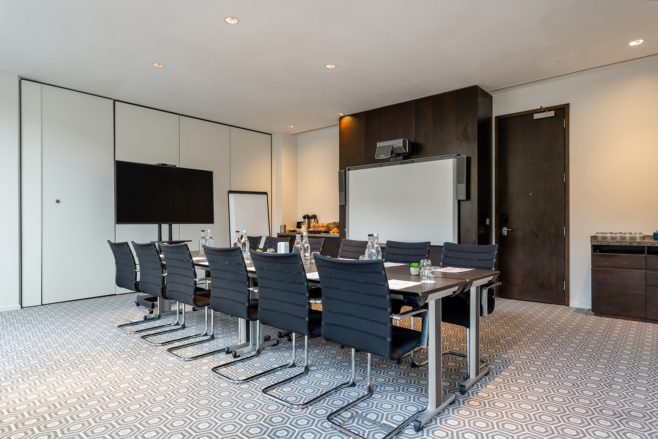 Modern meeting room with sleek table and natural light for productive events.