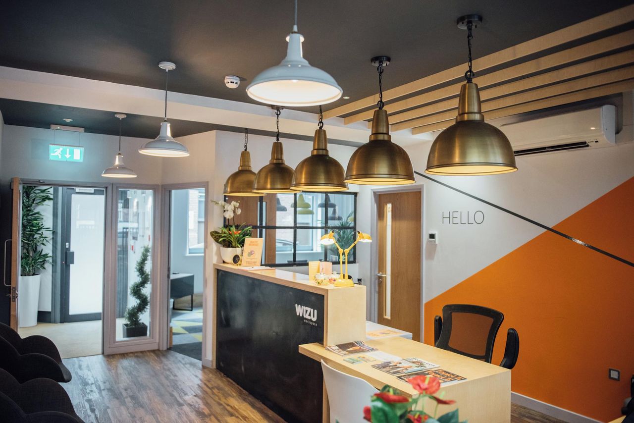 Modern reception area with warm lighting in Wizu Workspace for meetings and events.