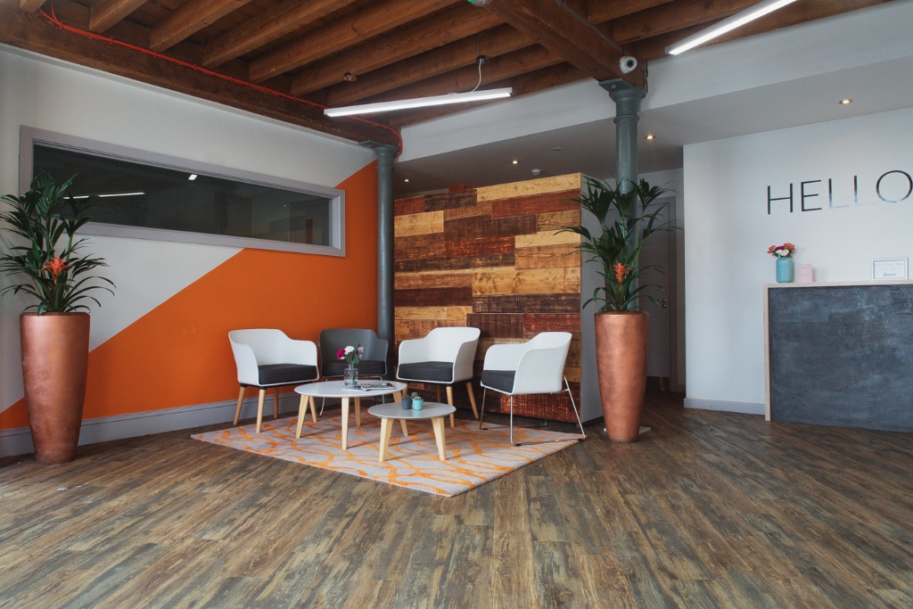 Modern reception area at Beck Mill, featuring orange accents for events and meetings.