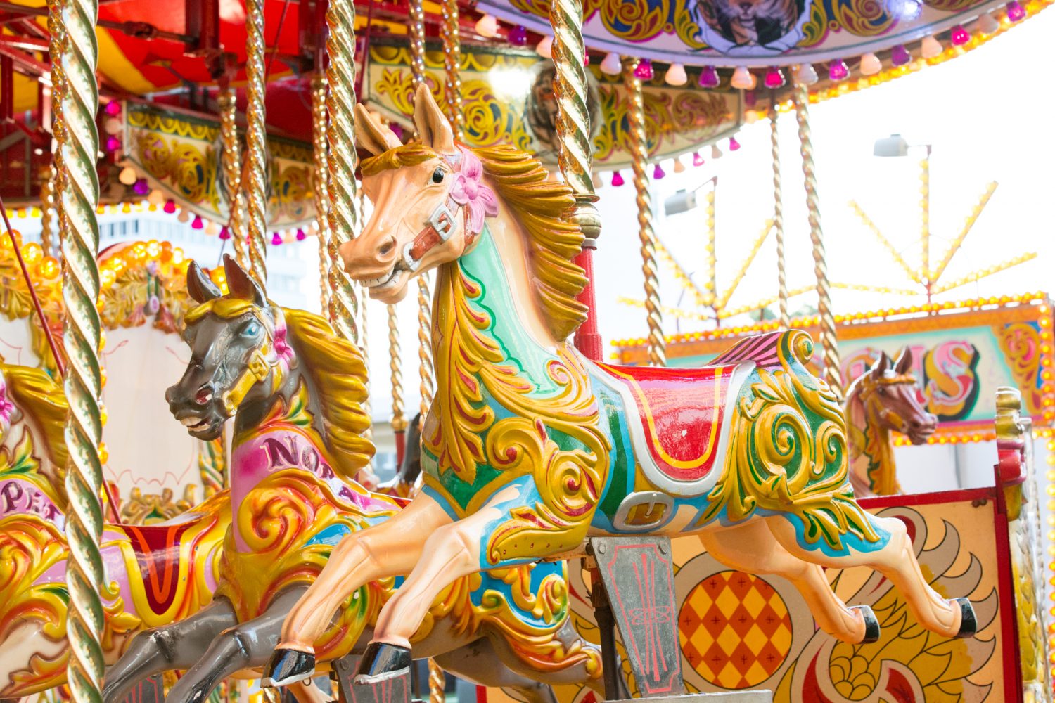 Vibrant carousel with ornate horses at City Central Funfair, perfect for family events.