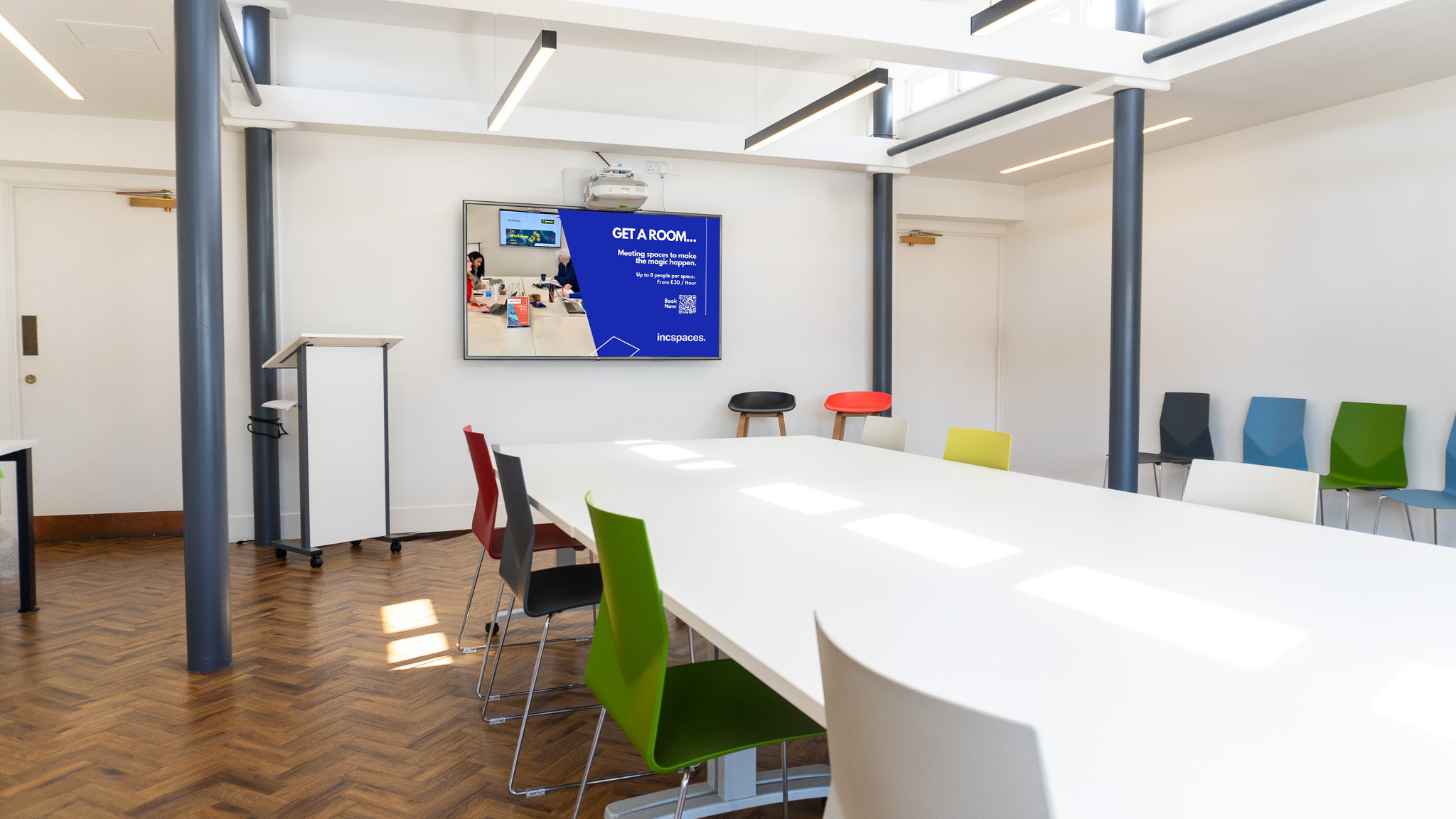 Modern meeting room with colorful chairs, ideal for workshops in Barcelona.