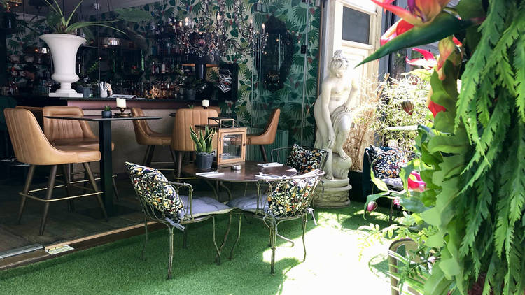 Private dining room at Rock & Rose Restaurant with lush greenery for intimate events.