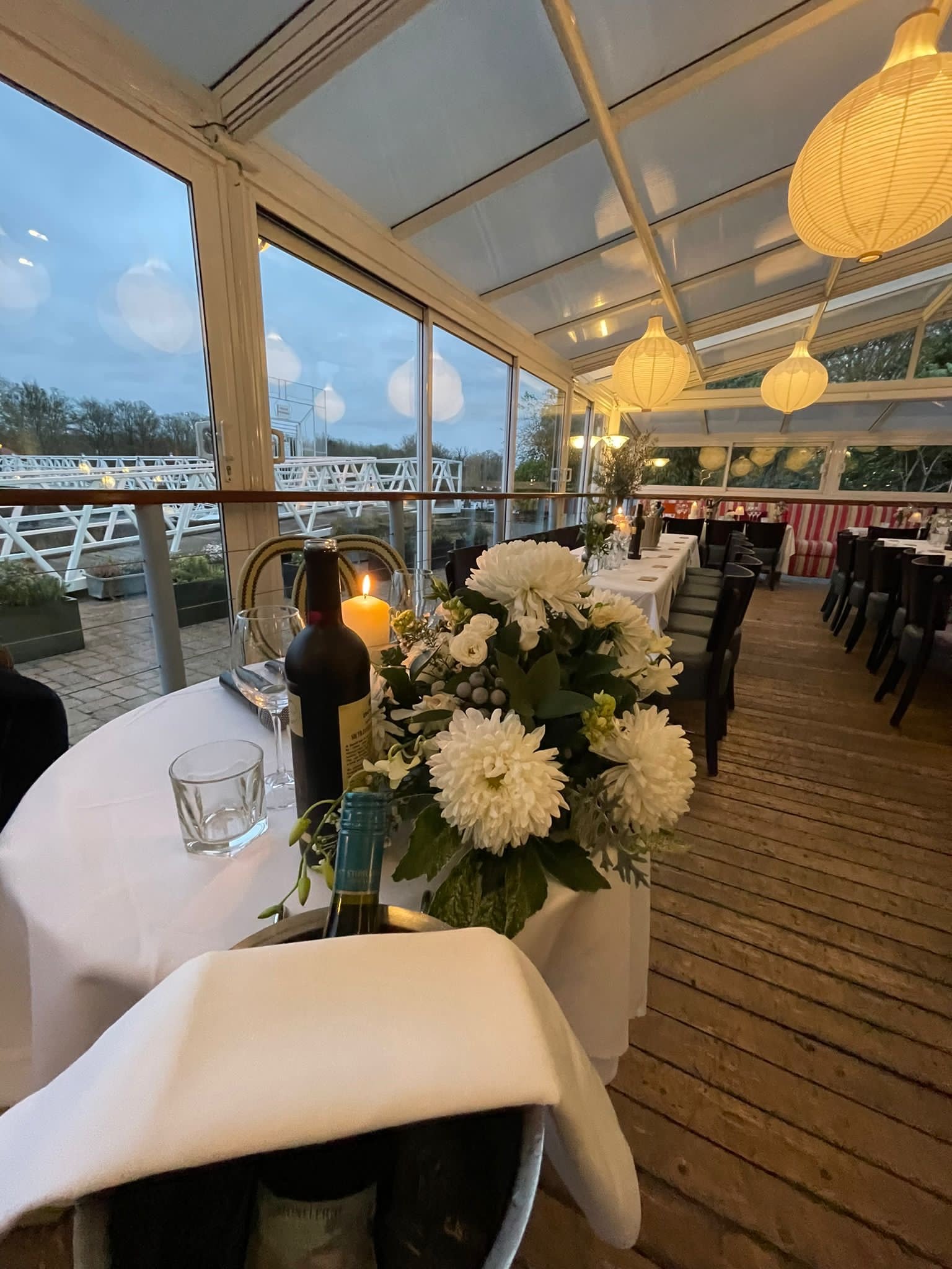 Elegant glass-walled dining room with floral centerpiece for intimate events at The Wharf Teddington.