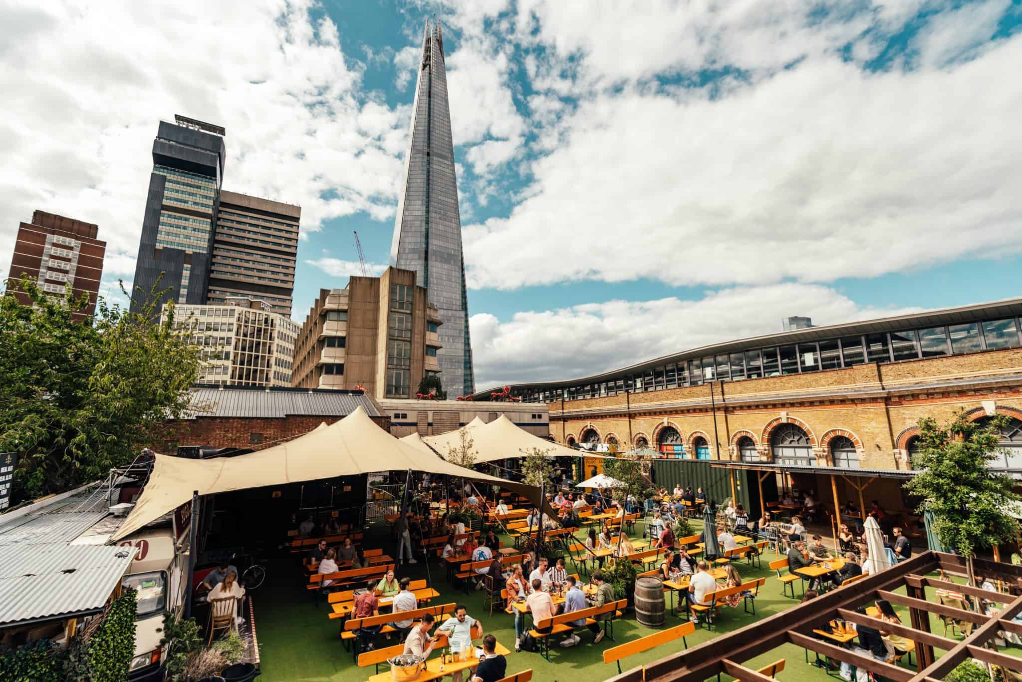 Beer garden at The Victoria with greenery and Shard backdrop, perfect for events.
