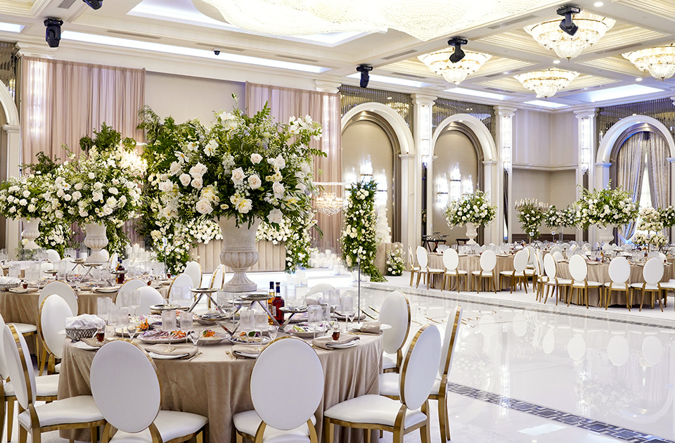 Elegant Grand Ballroom set for a high-end banquet with floral centerpieces. Wedding venue.