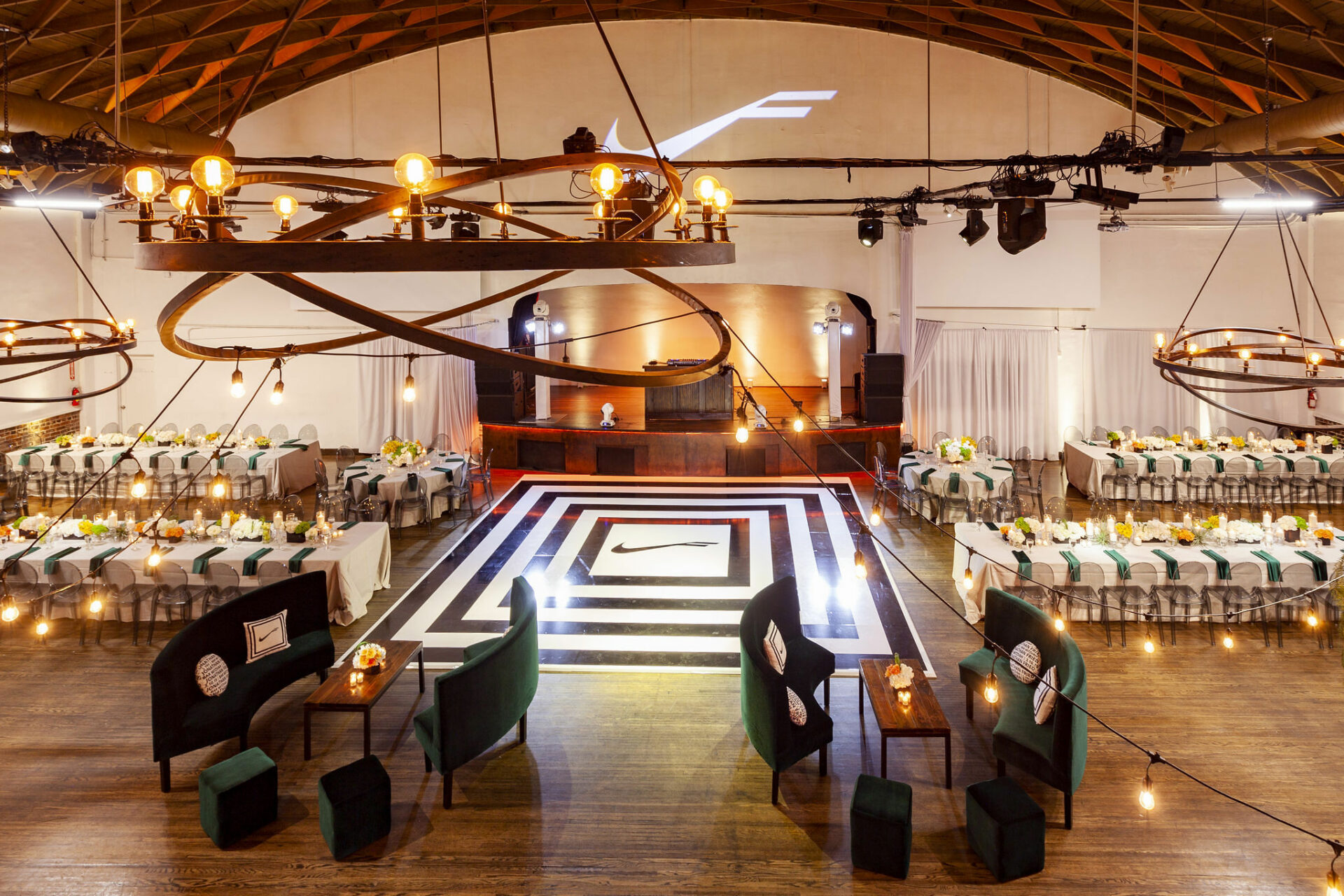 Elegant event space with round tables and lounge seating for gatherings and receptions.