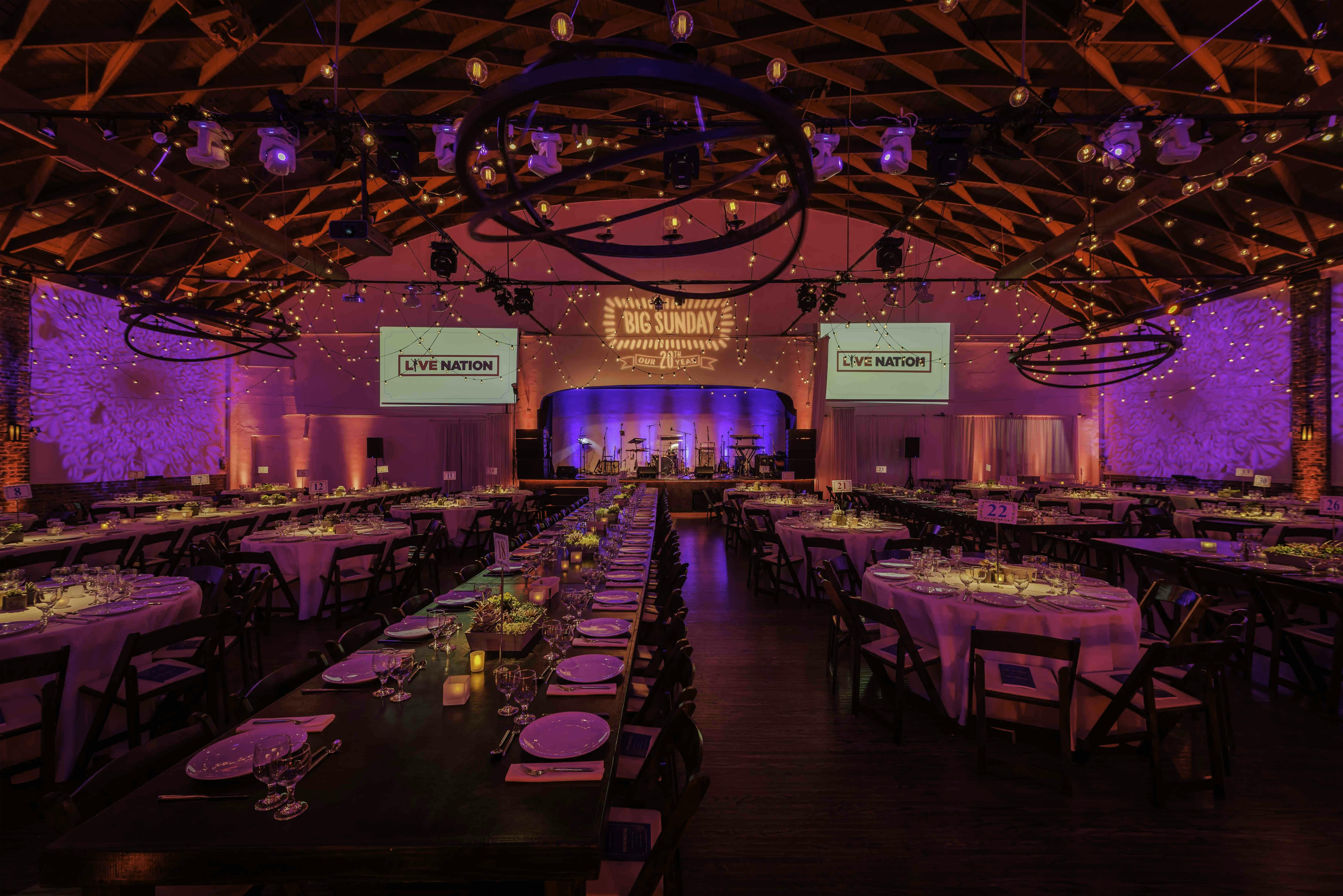Elegant gala event space at GALLERY Candela La Brea with ambient lighting and long tables.