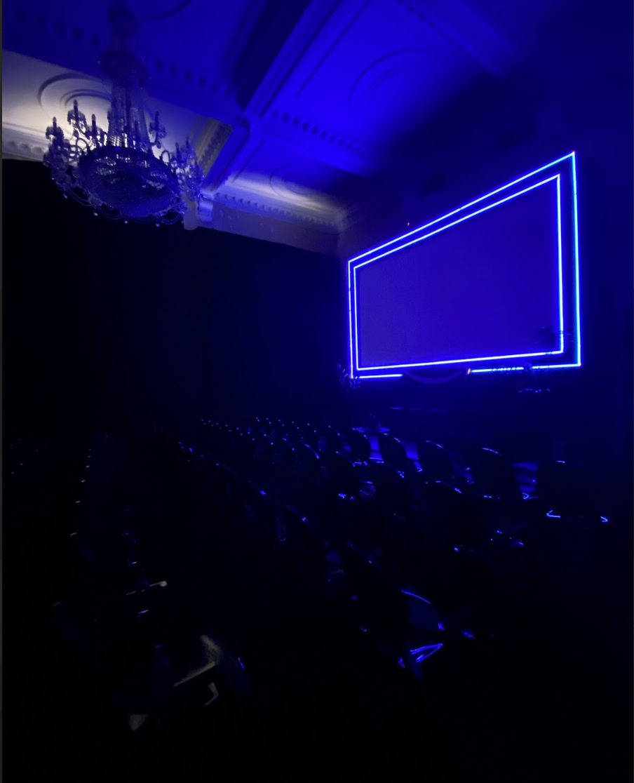 Modern event space with illuminated screen, perfect for presentations and performances.