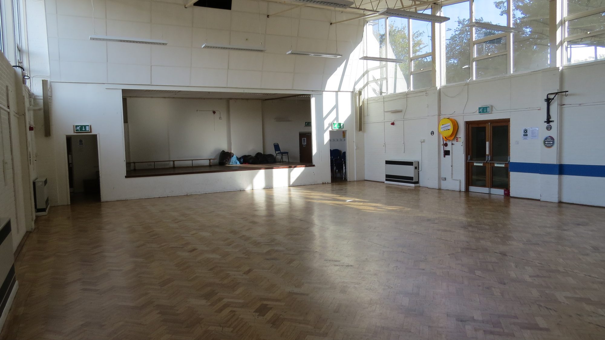 Spacious meeting room with wooden flooring for workshops and social gatherings.