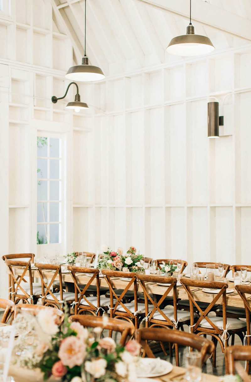 Elegant barn event space with long table, perfect for weddings and private dinners.