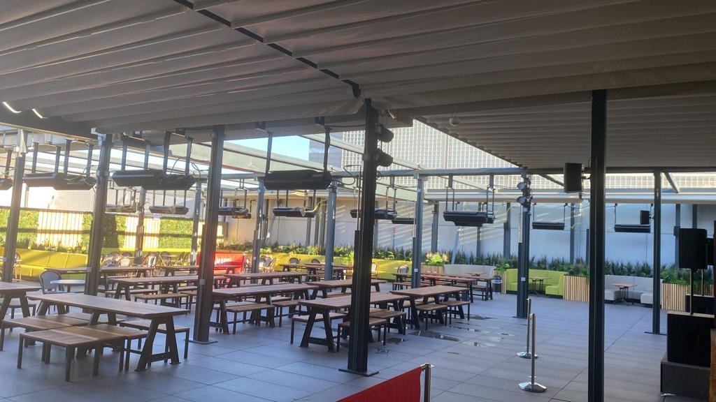 Spacious outdoor event venue with communal tables and modern design for gatherings.