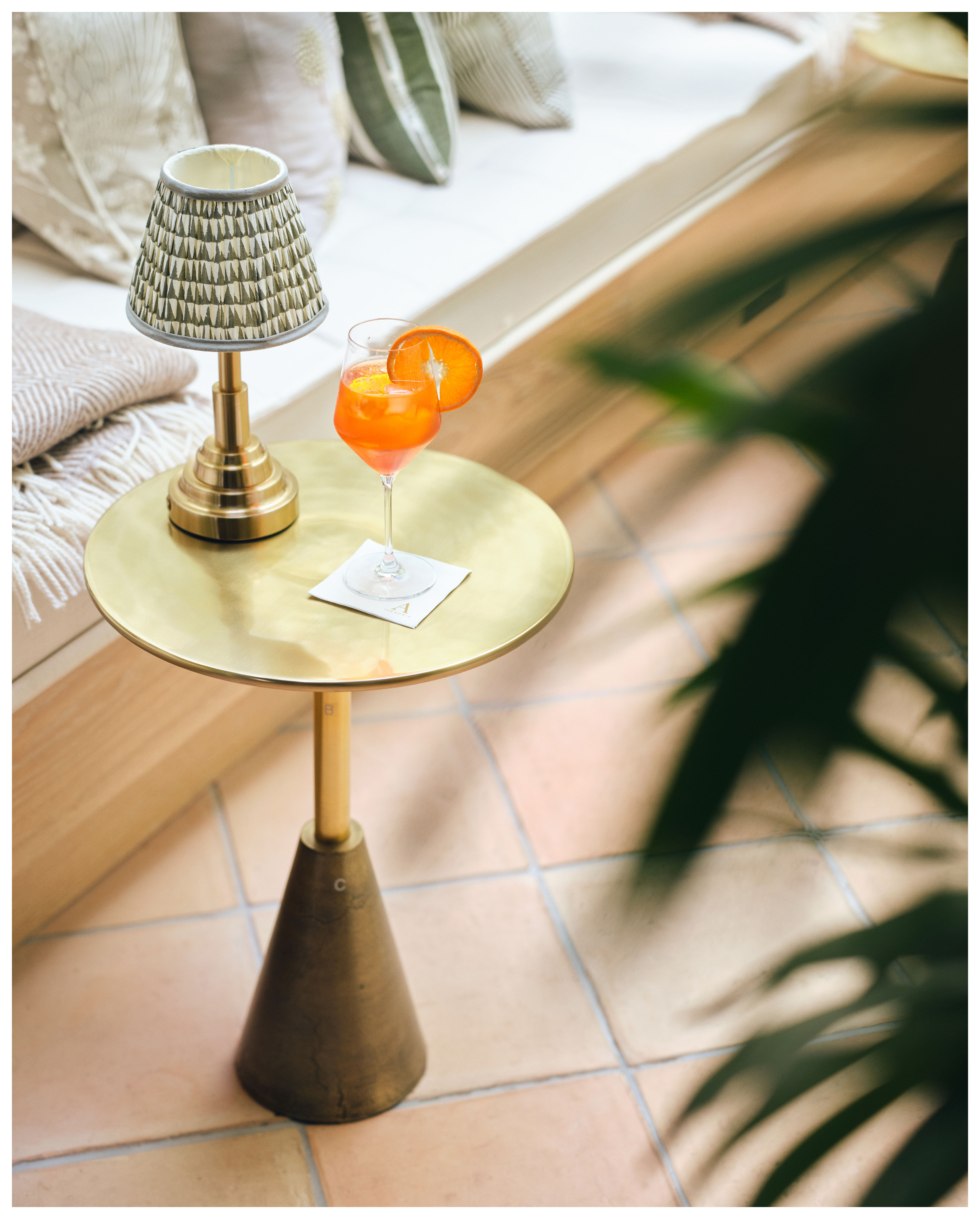 Elegant lounge side table with cocktail and lamp, perfect for networking events.