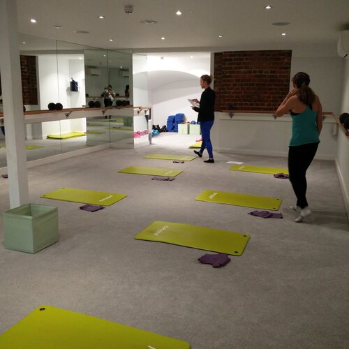 Barrecore Wandsworth fitness studio with green mats for wellness events and group exercises.