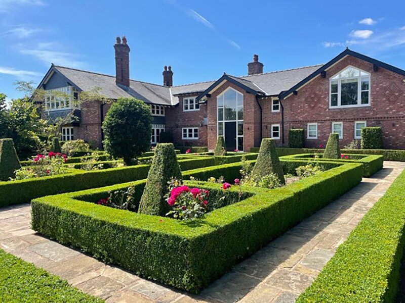 Elegant barn with manicured garden, perfect for outdoor events and parties.