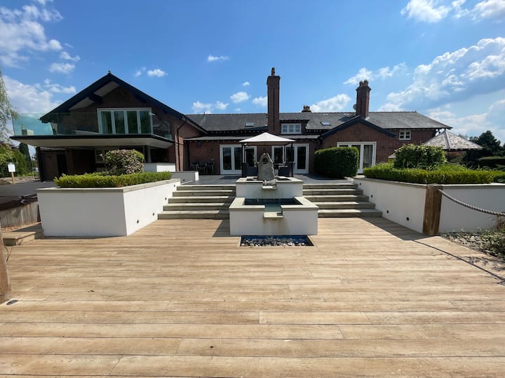 Spacious Fernside House barn with elegant landscaping and stylish water feature for events.