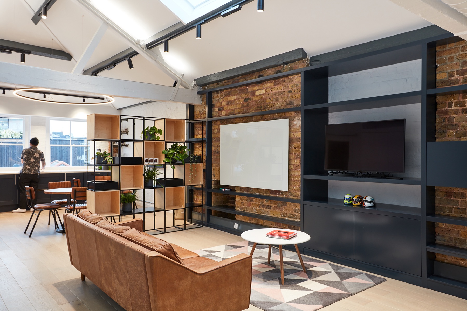 Modern meeting room with large screen, ideal for workshops and brainstorming sessions.