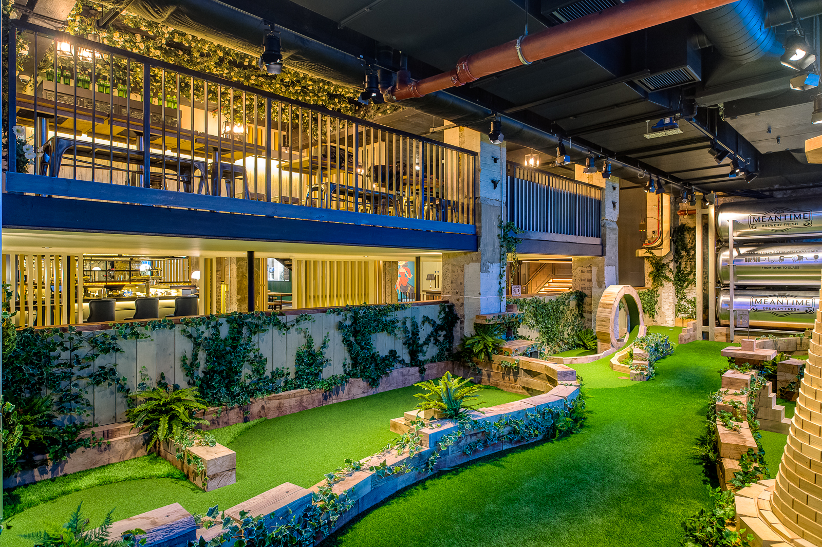 Vibrant multi-level event space with greenery, perfect for networking and gatherings.