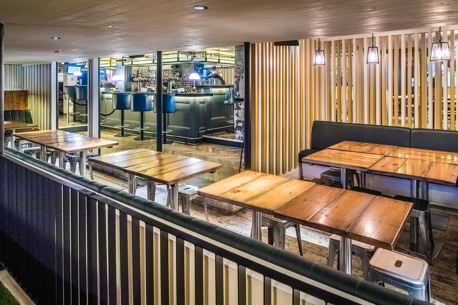 Modern event space with wooden tables, ideal for networking and casual meetings.