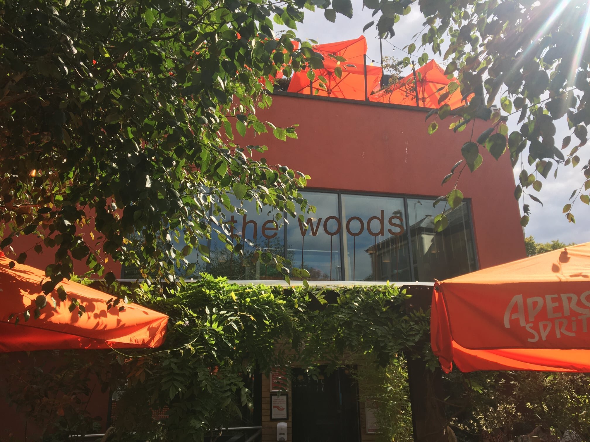 Vibrant outdoor pub with orange umbrellas, perfect for events and gatherings.