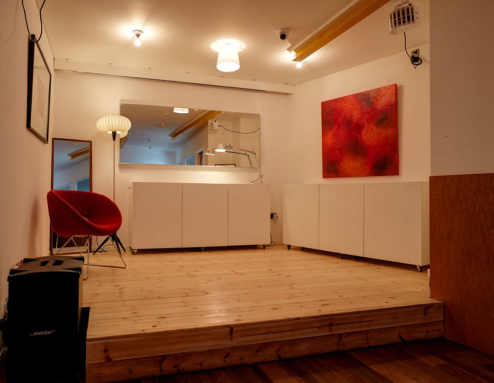 Versatile Second Floor Event Space with wooden flooring and red accent chair for gatherings.
