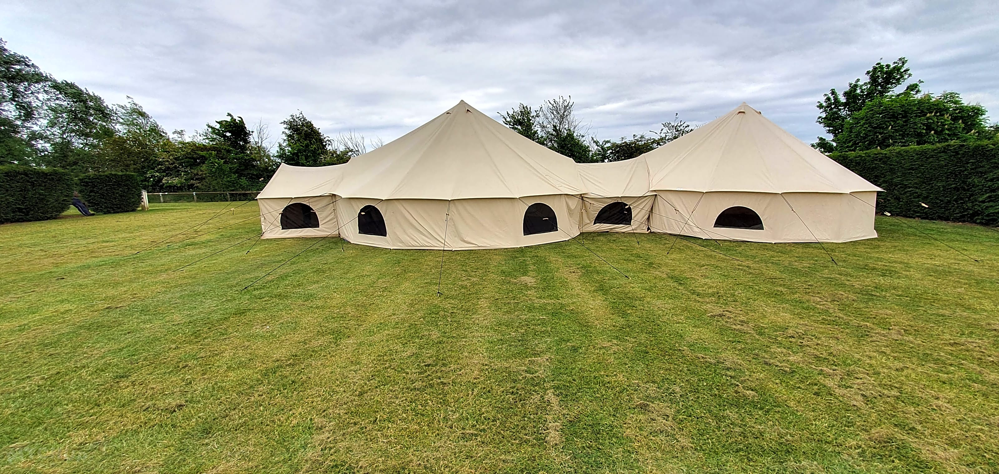 Elegant bell tent in lush park setting, perfect for weddings and retreats.