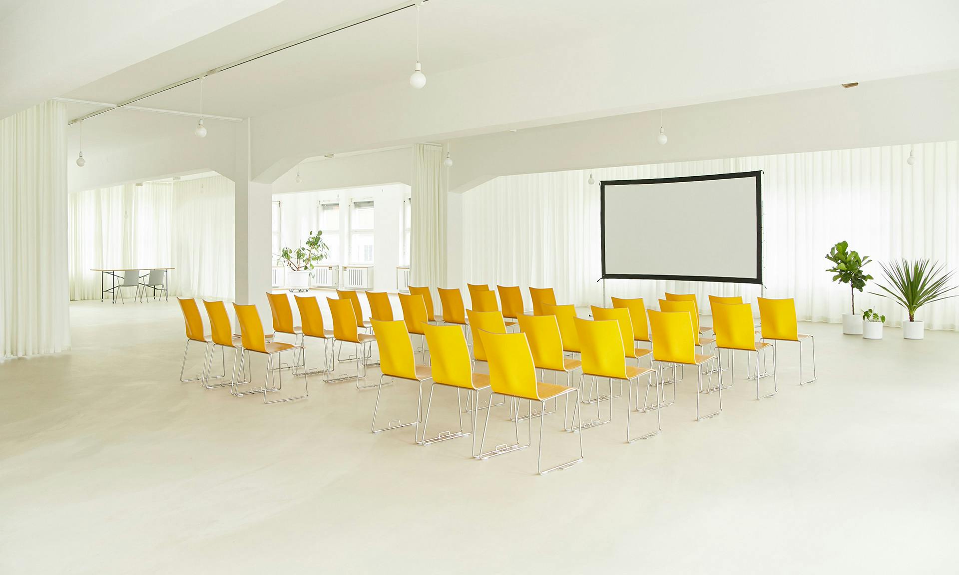 Modern function room with yellow chairs, perfect for workshops and seminars.