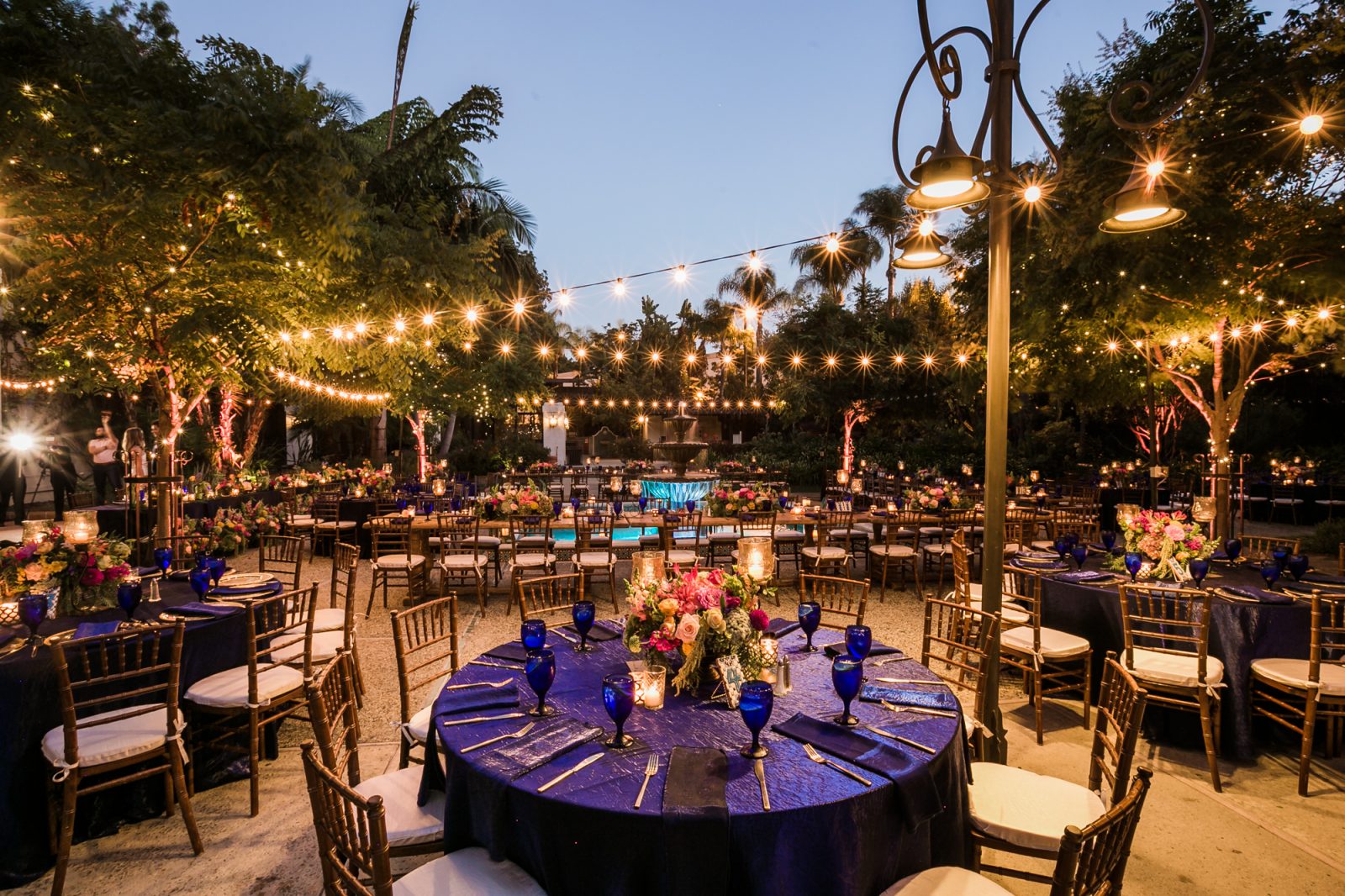 Elegant outdoor gala venue with floral centerpieces and string lights in Los Angeles.
