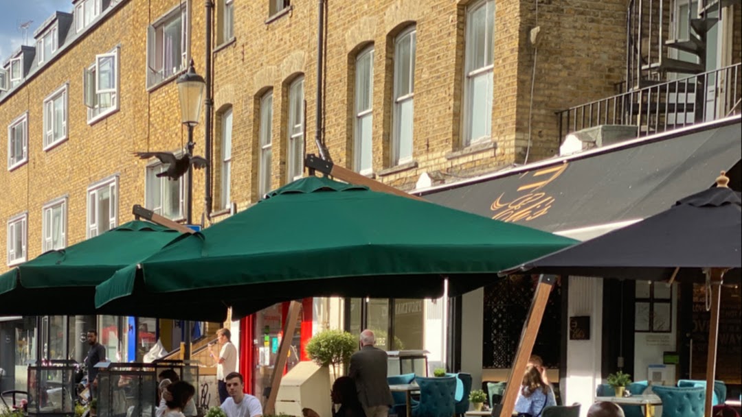 Eli's Restaurant outdoor café with green umbrellas, perfect for networking events and meetings.