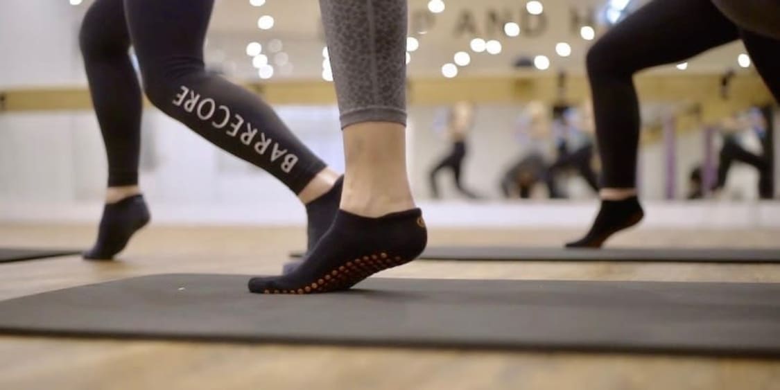 Dynamic Barrecore fitness class in Kensington, London; activewear for wellness events.