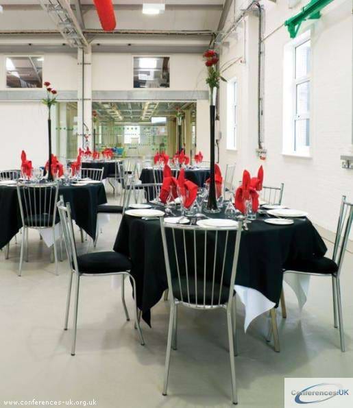 Elegant event space with round tables, black tablecloths for corporate gatherings.