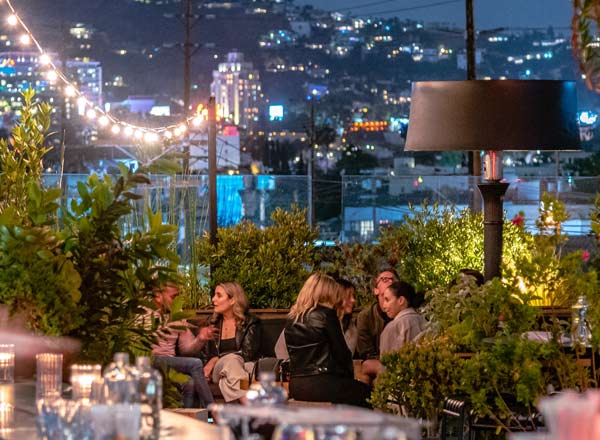 Vibrant rooftop event space with city skyline, perfect for networking and social gatherings.