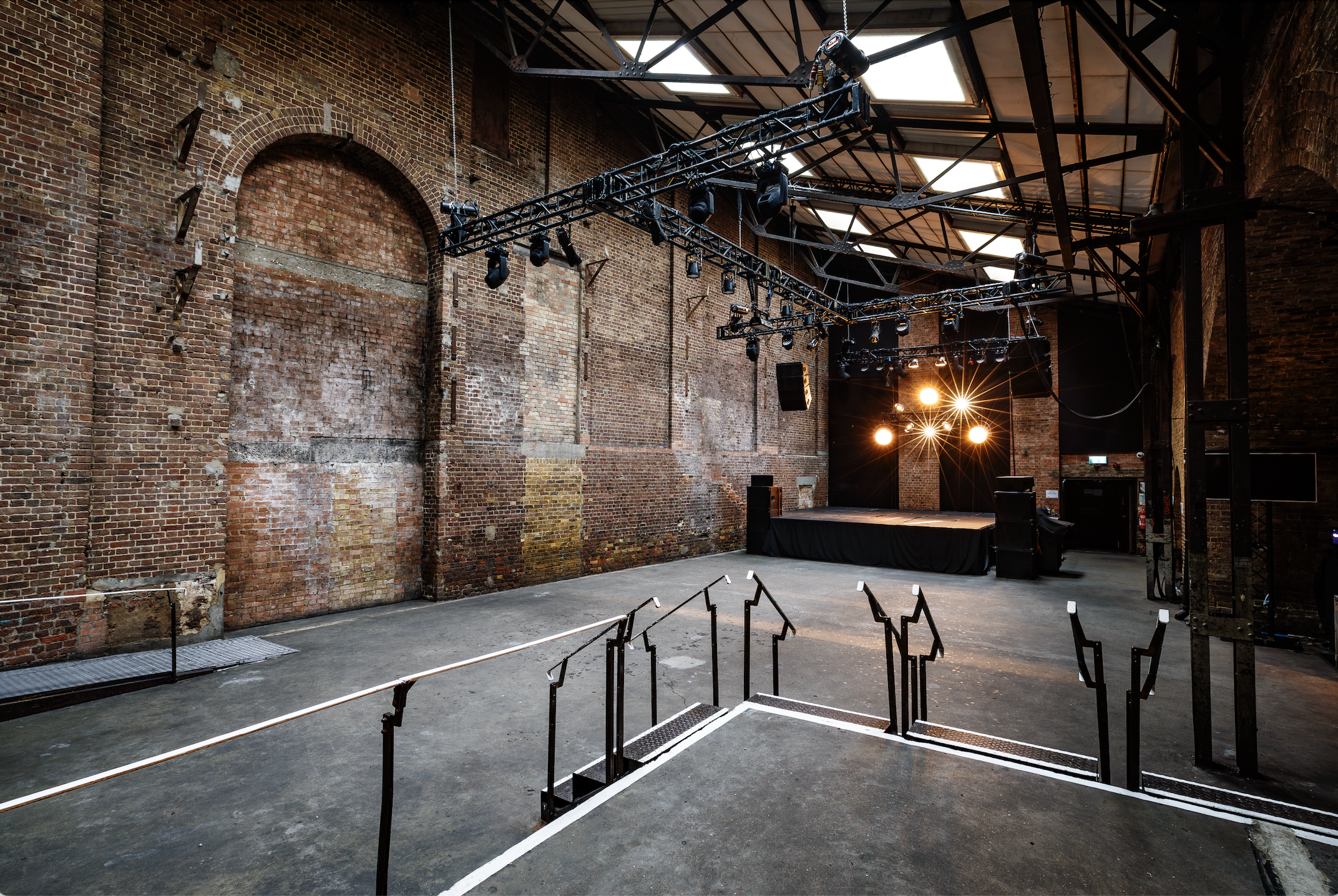 Spacious industrial venue with exposed brick, perfect for events and performances.