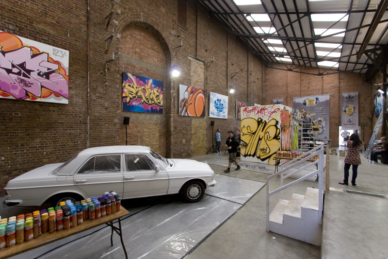 Vibrant event space with graffiti art and classic car for urban-themed gatherings.