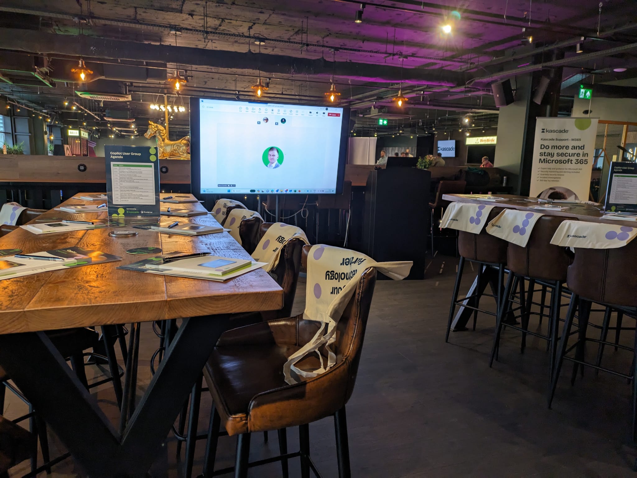 Modern meeting space in Par 59 Bristol with long tables and a large presentation screen.