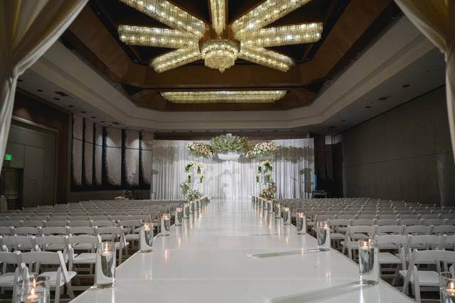 Elegant wedding ceremony setup in Vineyard Room with floral backdrop and chandelier.