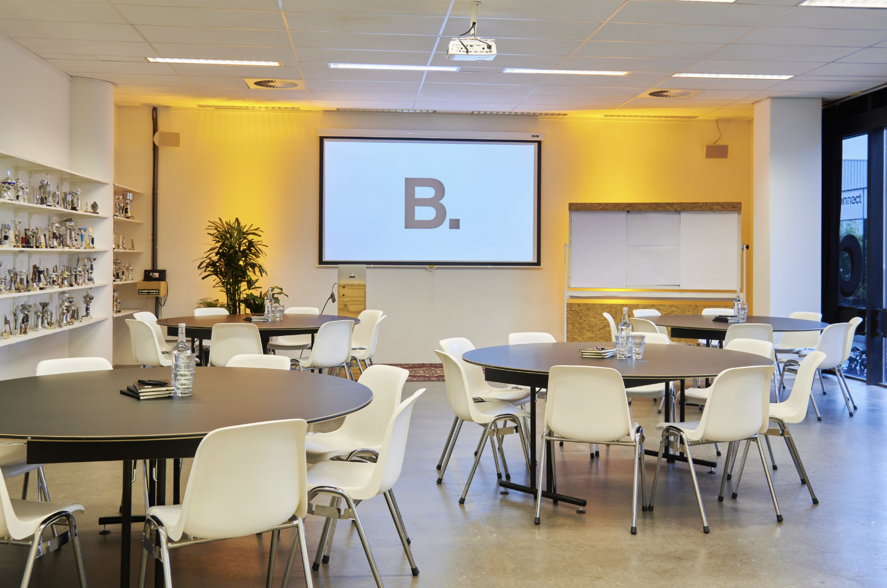 Versatile meeting space with round tables, ideal for workshops and presentations in B. Amsterdam.