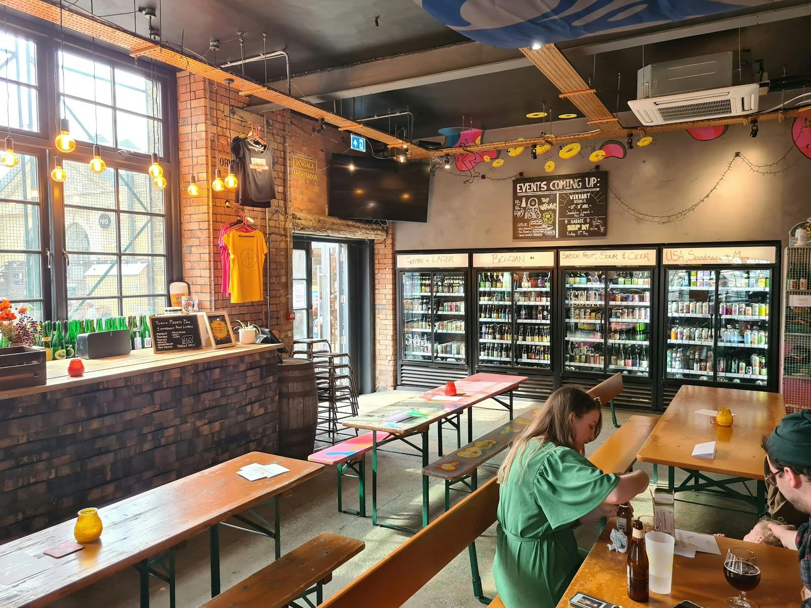 Vibrant Taproom with communal tables, perfect for creative events and social meetups.