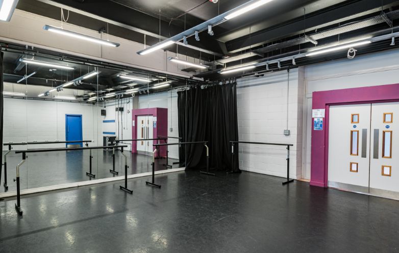 Versatile Black Room studio with mirrored walls for meetings and events.