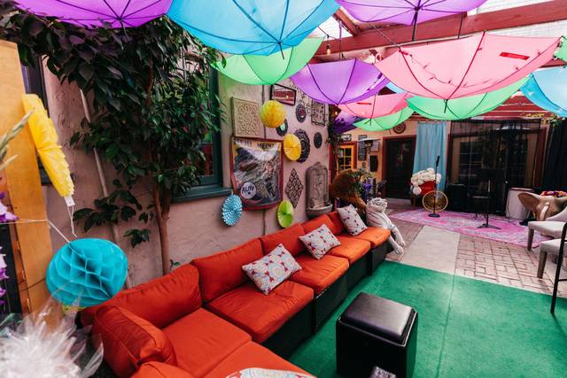 Vibrant covered patio with colorful umbrellas for outdoor gatherings in Bexx Secret Garden.