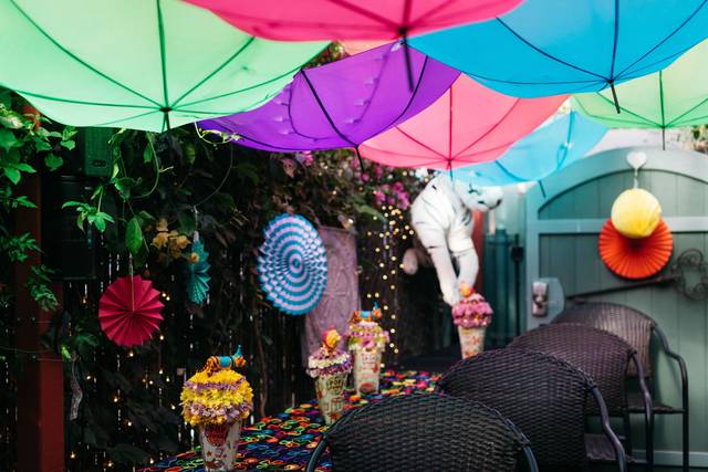 Vibrant outdoor event space with colorful umbrellas for summer gatherings and children's parties.