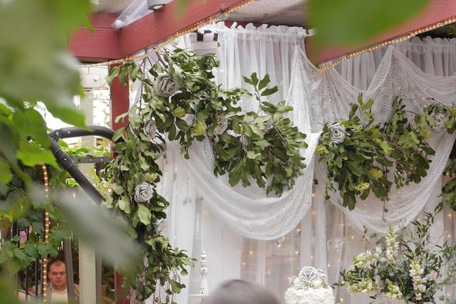 Elegant event space with drapery and greenery, perfect for weddings and gatherings.