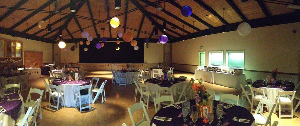 Elegant banquet hall with round tables and vibrant lanterns for events and celebrations.