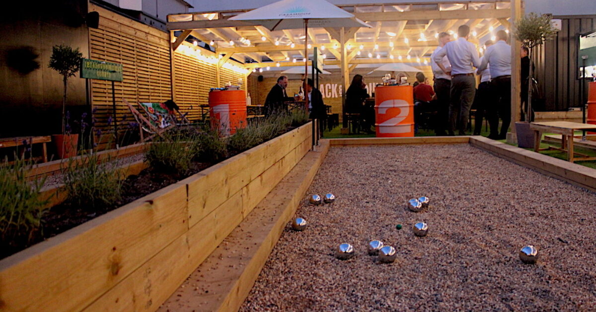 Vibrant outdoor event space with bocce ball court for networking and team-building.