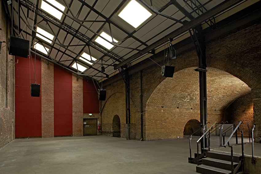Spacious industrial venue with high ceilings, perfect for events and performances.