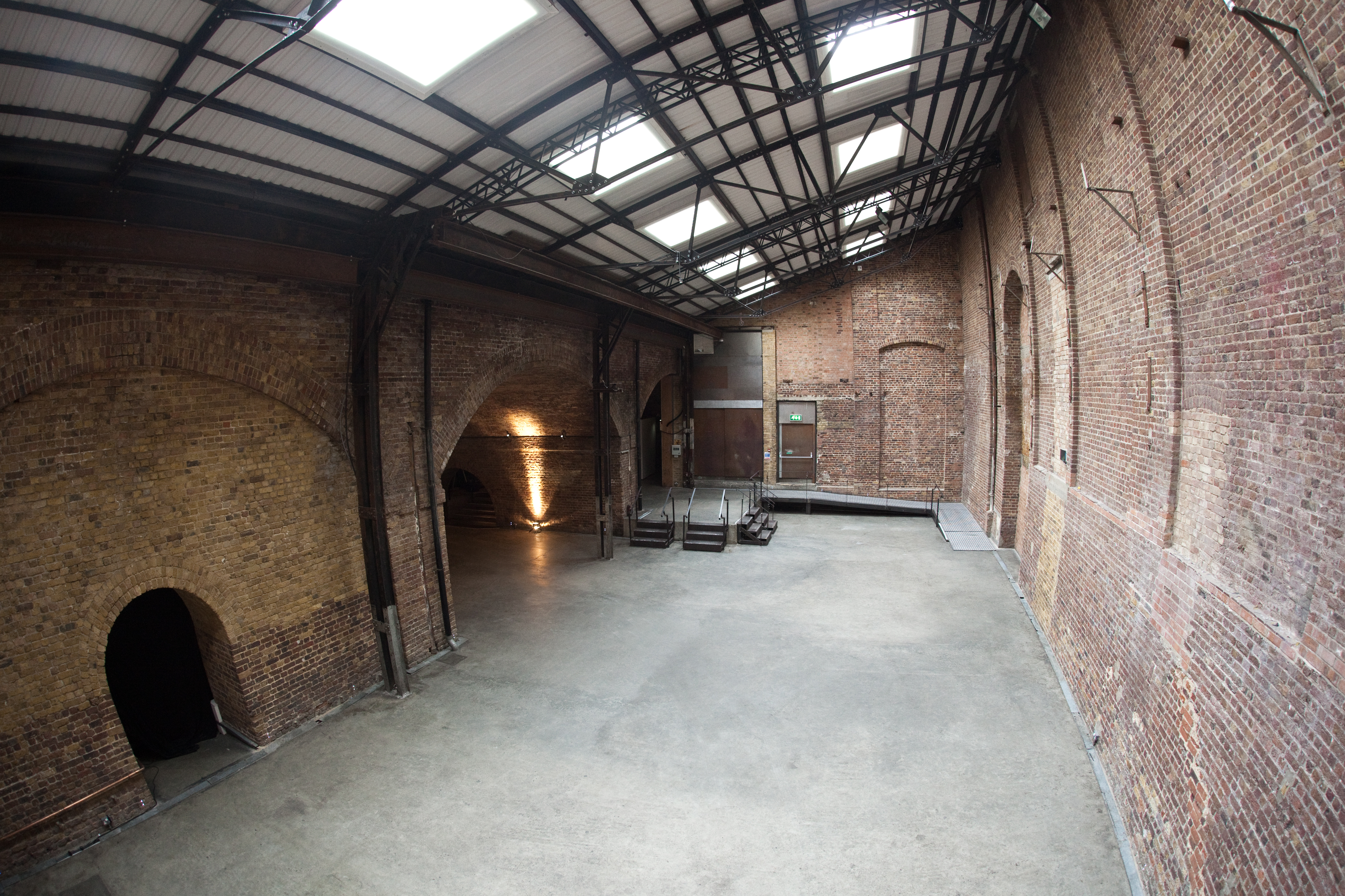 Spacious industrial venue with exposed brick, perfect for creative events and gatherings.