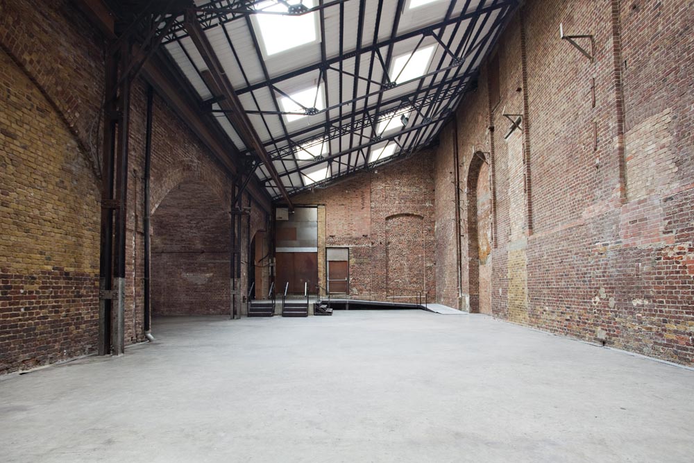 Spacious industrial venue with exposed brick, perfect for creative events and gatherings.