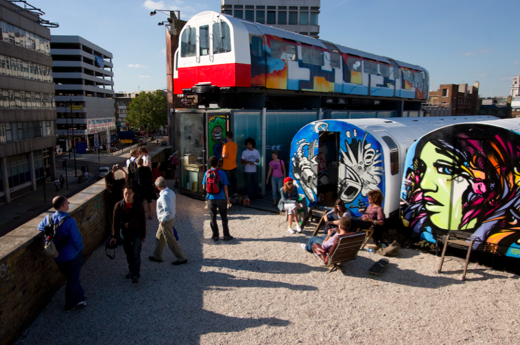 Vibrant urban venue with repurposed train cars for creative workshops and networking events.
