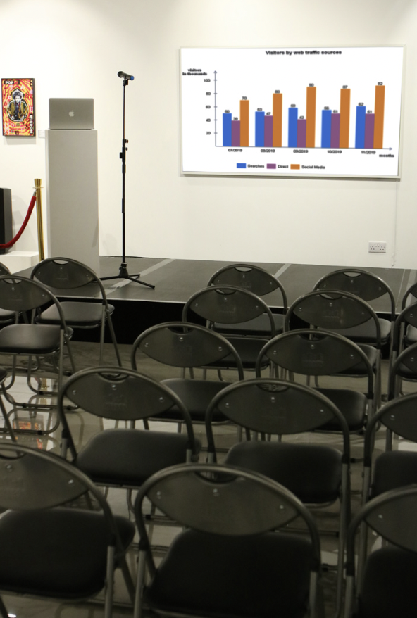 Brunswick Art Gallery event setup with stage, microphone, and folding chairs for presentations.